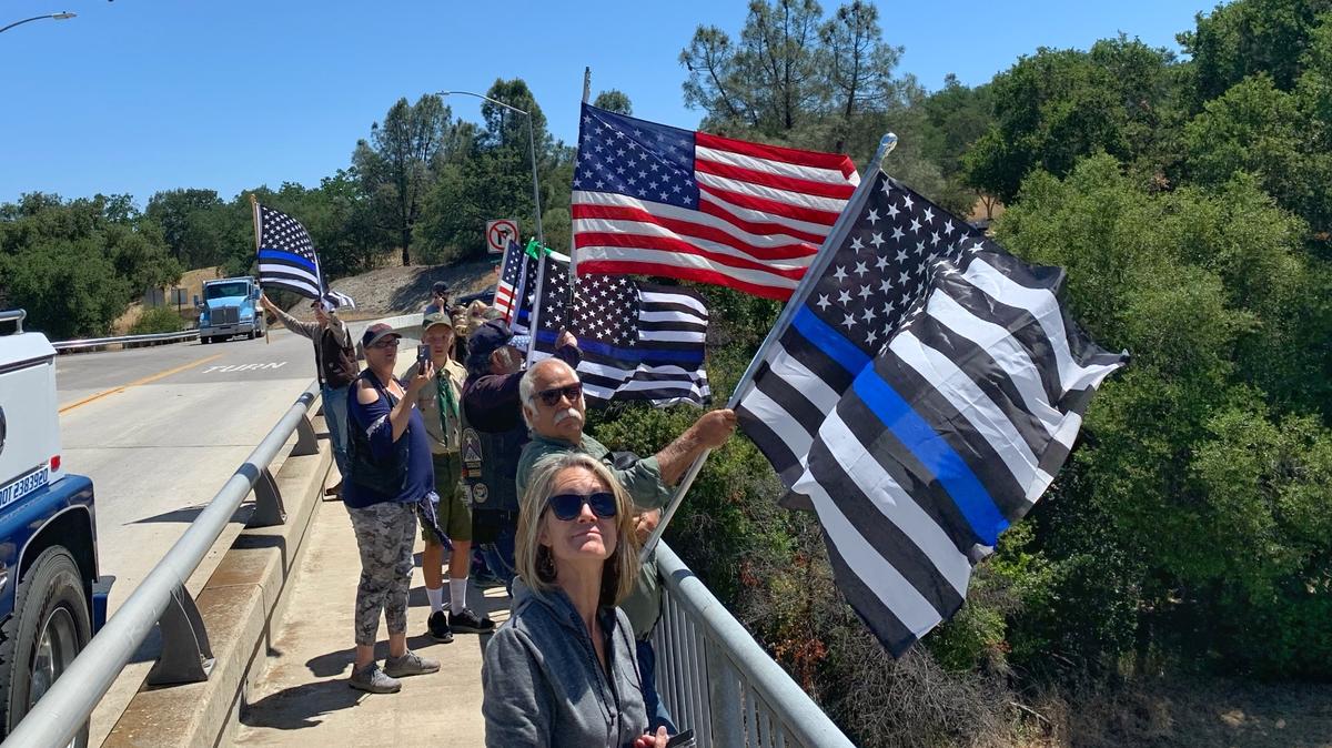 People gathered on a Highway 101 overpass in Atascadero to watch the funeral procession of Det. Luca Benedetti, who was killed in San Luis Obispo on May 10.