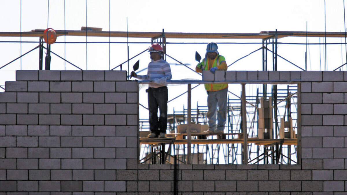 Masons work on a wall of the Tractor Supply Co. building under construction at the corner of Tank Farm Road and South Higuera Street in San Luis Obispo. The company plans to build a new one in Fresno. 