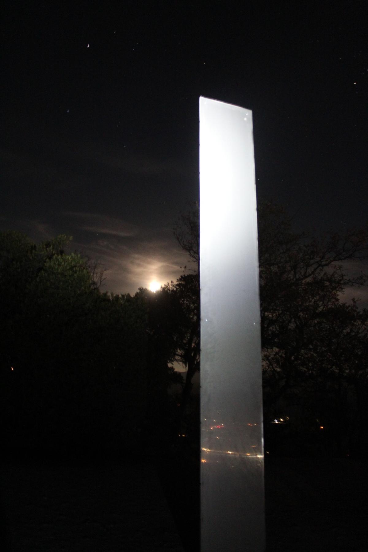 The moon rises Wednesday night behind the monolith on Atascadero’s Pine Mountain. The structure was removed Thursday.