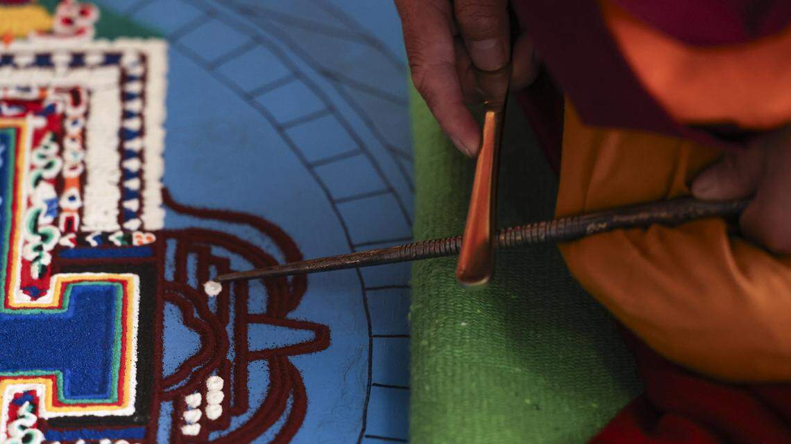 Ven. Rigzin uses a tool to distribute sand. Buddhist monks from Tibet were in Atascadero creating a Medicine Buddah Sand Mandala, with the intention to distribute healing energy to all sentient beings and eliminate suffering on Oct. 23, 2025.