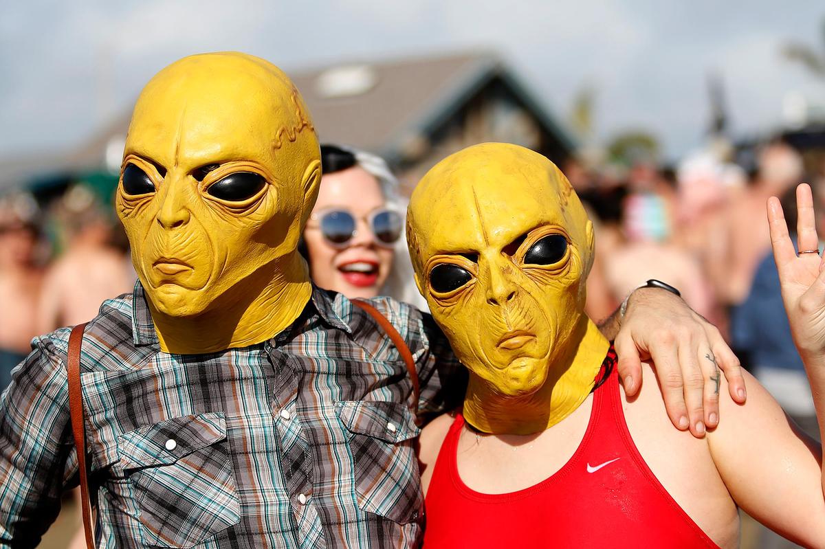 Jeremy Engel, of Pennsylvania and Molly Pendley of San Luis Obispo wear alien masks. The 43rd Carlin Soule Memorial Polar Bear Dip invites community members to don swimsuits and silly costumes before welcoming the new year by running into the waves.
