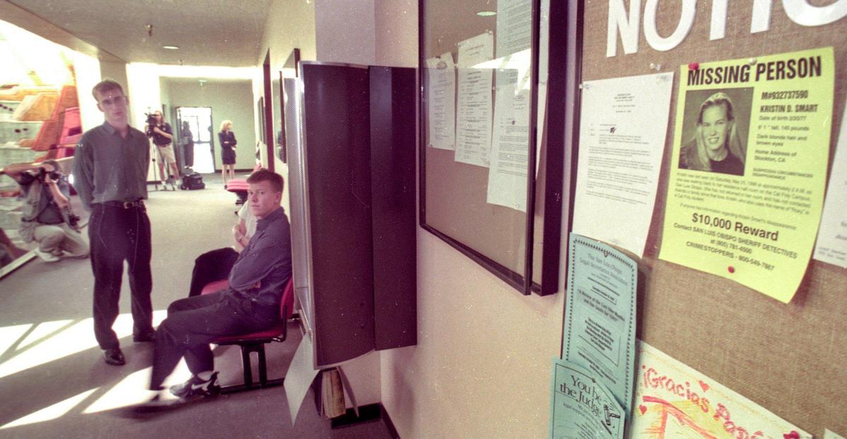 Paul Flores, seated, waits to testify before the county grand jury about Kristin Smart’s disappearance. Flores was the last person seen with Smart. A missing person’s poster hangs on the wall of the courthouse Oct. 17, 1996.