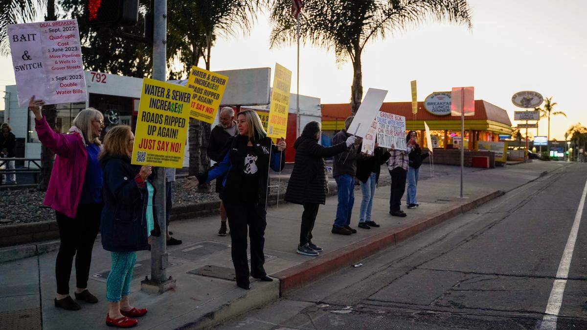 Grover Beach residents protest a proposed 112% water rate increase over the next five years, before the Grover Beach City Council meeting on Nov. 13, 2023. Some residents said they have started knocking on doors, encouraging their neighbors to write letters of protest against the project.