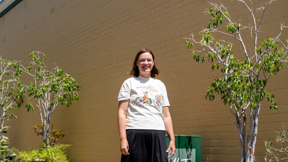 Monarch Books owner Taneesha Regez poses for a photo in front of the western wall of her store in Arroyo Grande's Village on Wednesday, April 15, 2026. A planned mural will depict a monarch butterfly, books, a UFO and Central Coast wildlife.