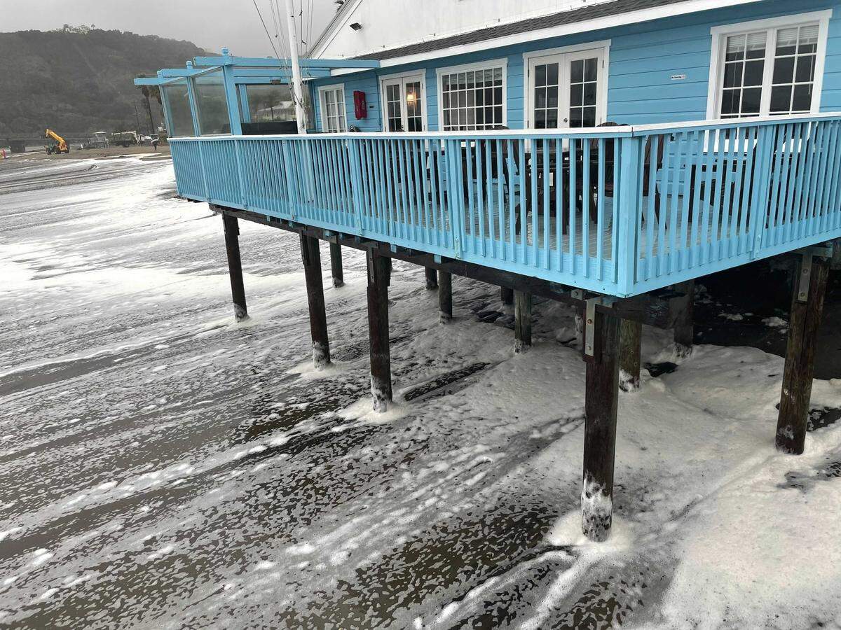Foamy waves wash up on the beach below the San Luis Yacht Club in Avila Beach on Thursday, Jan. 28, 2021.