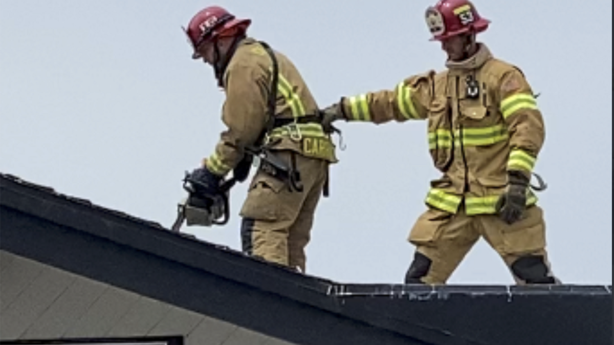 Morro Bay Fire firefighters work on the rooftop at The Libertine Pub on the Embarcadero.