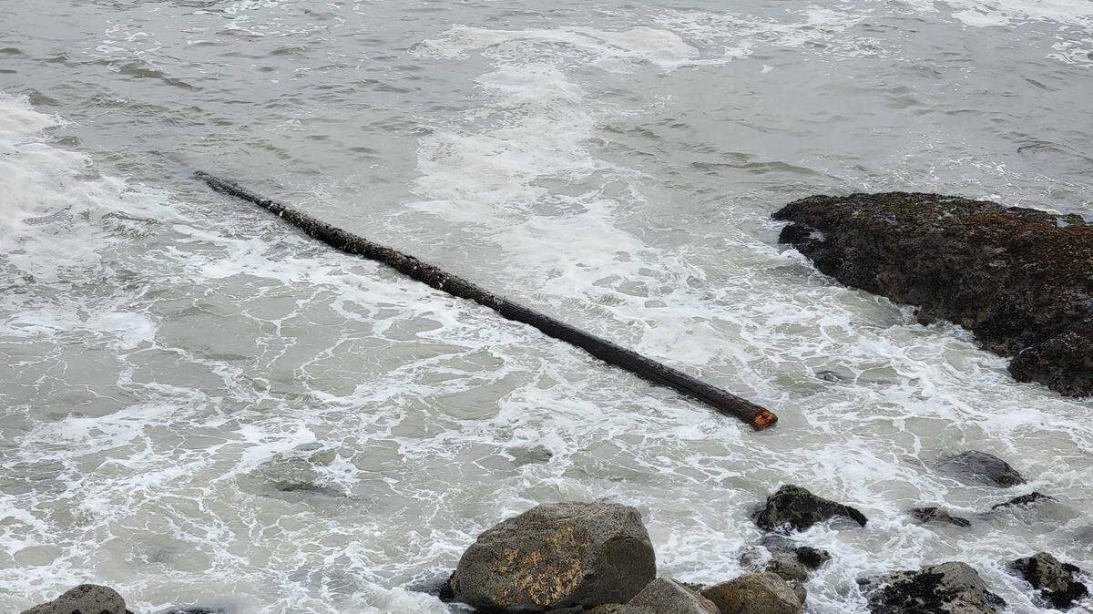 An apparent pier piling floats in the surf at Avila Beach on Tuesday, Dec. 14, 2021. It’s unclear where the piling was from.
