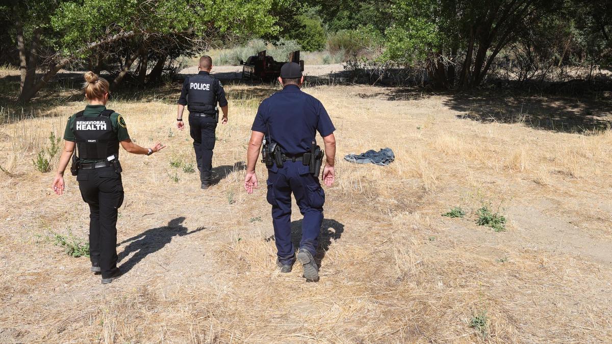 Members of the Paso Robles Police Department and San Luis Obispo County Behavioral Health have stepped up outreach in the Salinas River, where there is fire risk and junk accumulation. Sara Craft with San Luis Obispo County behavioral health, left, and Officer Garrett Silva and Sgt. Terry Afana of the Paso Robles Police Department walk out through the dry waterway.