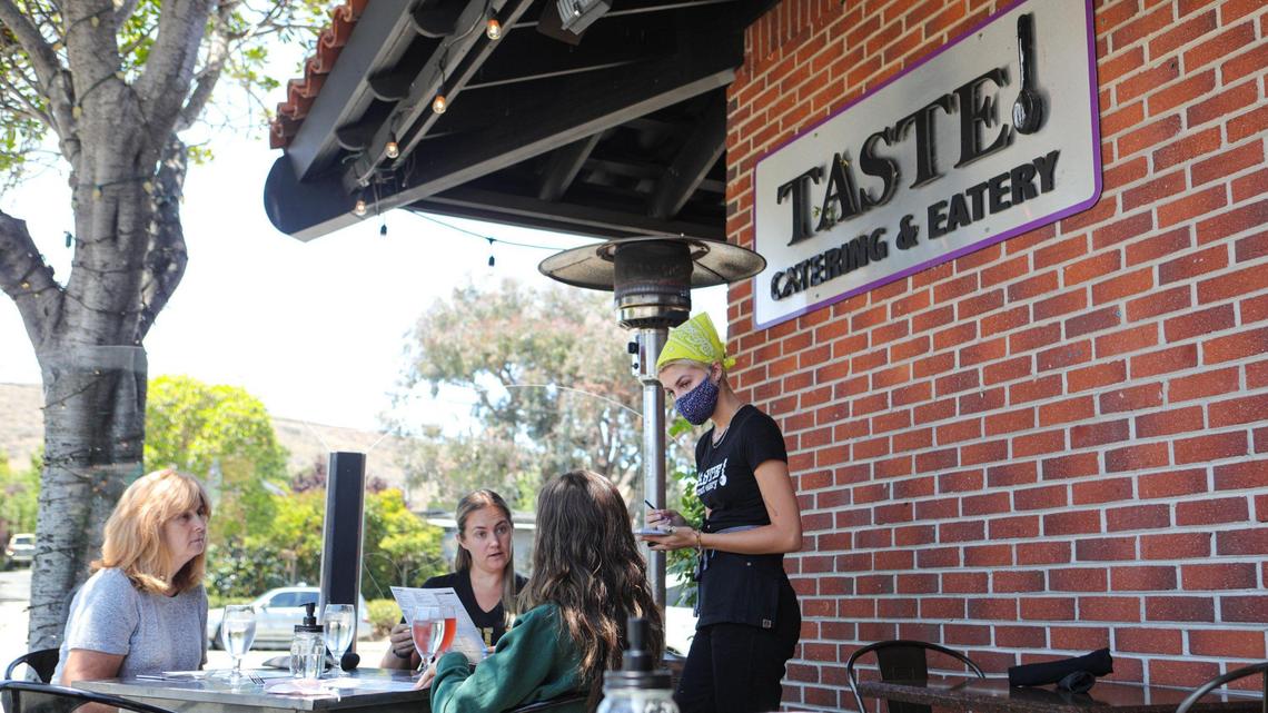 Server Emma Lukin goes over the menu choices with from left: Jeanine Seagraves, Chelsey Seagraves and Madison Seagraves. Taste Restaurant on Broad Street has expanded its outdoor seating options since indoor dining is no longer allowed.