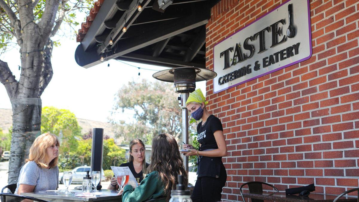 Server Emma Lukin goes over the menu choices with from left: Jeanine Seagraves, Chelsey Seagraves and Madison Seagraves. In July, Taste Restaurant on Broad Street expanded its outdoor seating options. The restaurant urges state officials to lift restrictions due to severe business impacts, saying it can be done safely.