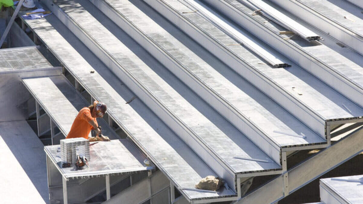 Harryson Heilman assembles parts Wednesday on a new grandstand behind the south end zone of Alex G. Spanos Stadium. Cal Poly is having the temporary bleachers behind the south end zone replaced with permanent ones.