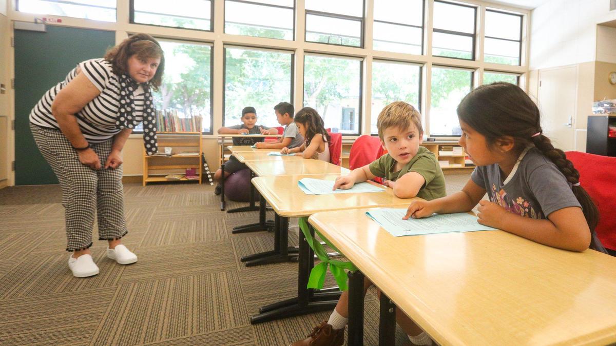 Carrisa Plains Elementary School Principal Lindsay Lopez helps kindergarten students get started on a lesson. Lizbeth Camarillo Jimenez and Isabella Sisco work on computers.