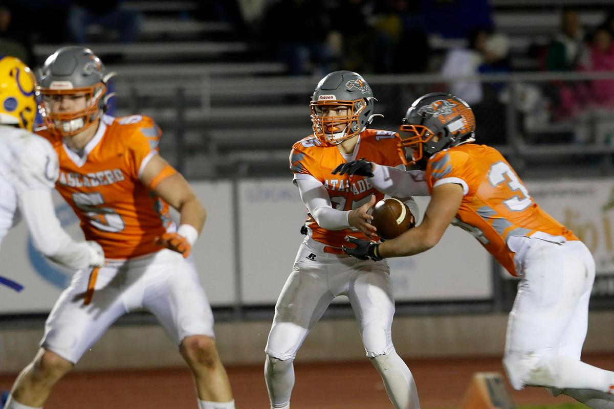 Greyhound quarterback Kane Cooks (15) hands the ball to Trey Cooks (34). Atascadero High School Greyhounds beat Dos Palos Broncos 35-0 in the prep football semifinals, Friday, Nov. 18, 2022.