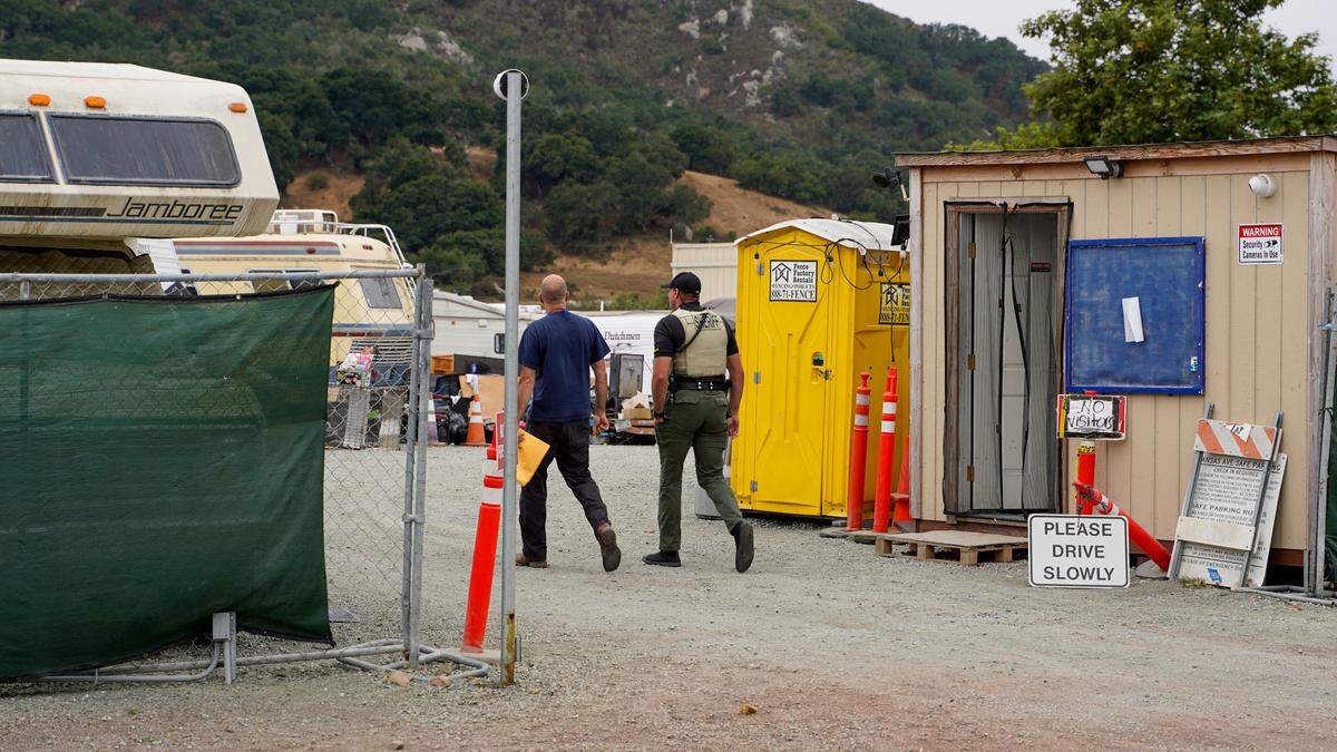 San Luis Obispo County homeless services division manager Jeff Al-Mashat and a San Luis Obispo County Sheriff’s Office deputy enter the Oklahoma Avenue Safe Parking Site to inform six residents they were evicted.