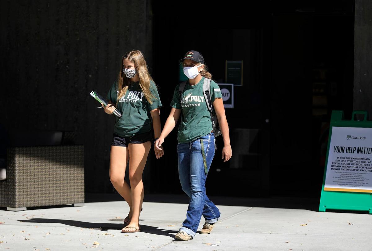 Two Cal Poly students wear mask as they walk on campus in September. Cal Poly reported its first COVID-19 case involving a student in March 2020.