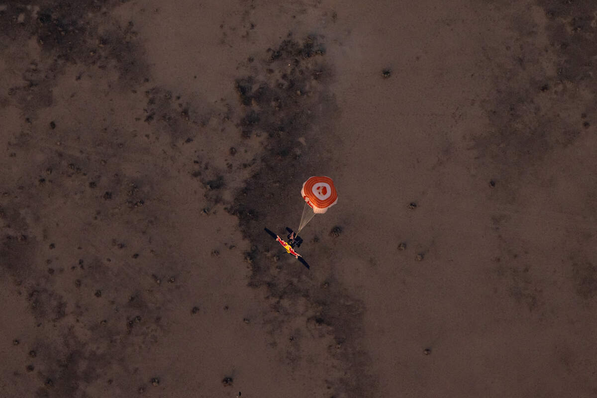 The blue plane parachutes back to earth after Andy Farrington was unable to enter and land it as part of the daredevil plane swap attempted April 24, 2022, in Arizona.