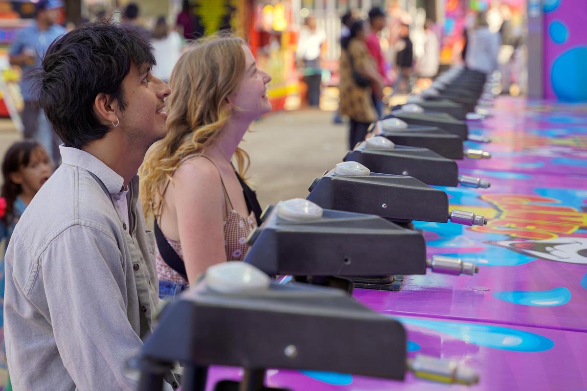 Tribune reporters Angel Corzo, left, and Sasha Tuddenham play a water race game at the California Mid-State Fair on Wednesday, July 16, 2025. The Mid-State Fair will run from July 16-27.