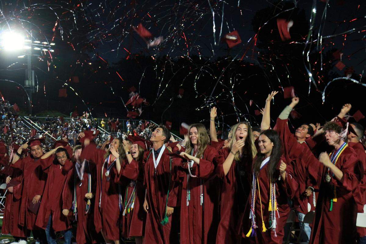 Graduates from Paso Robles High School’s class of 2022 toss their hats and celebrate as confetti falls during their commencement ceremony on June 10, 2022, at the War Memorial Stadium.