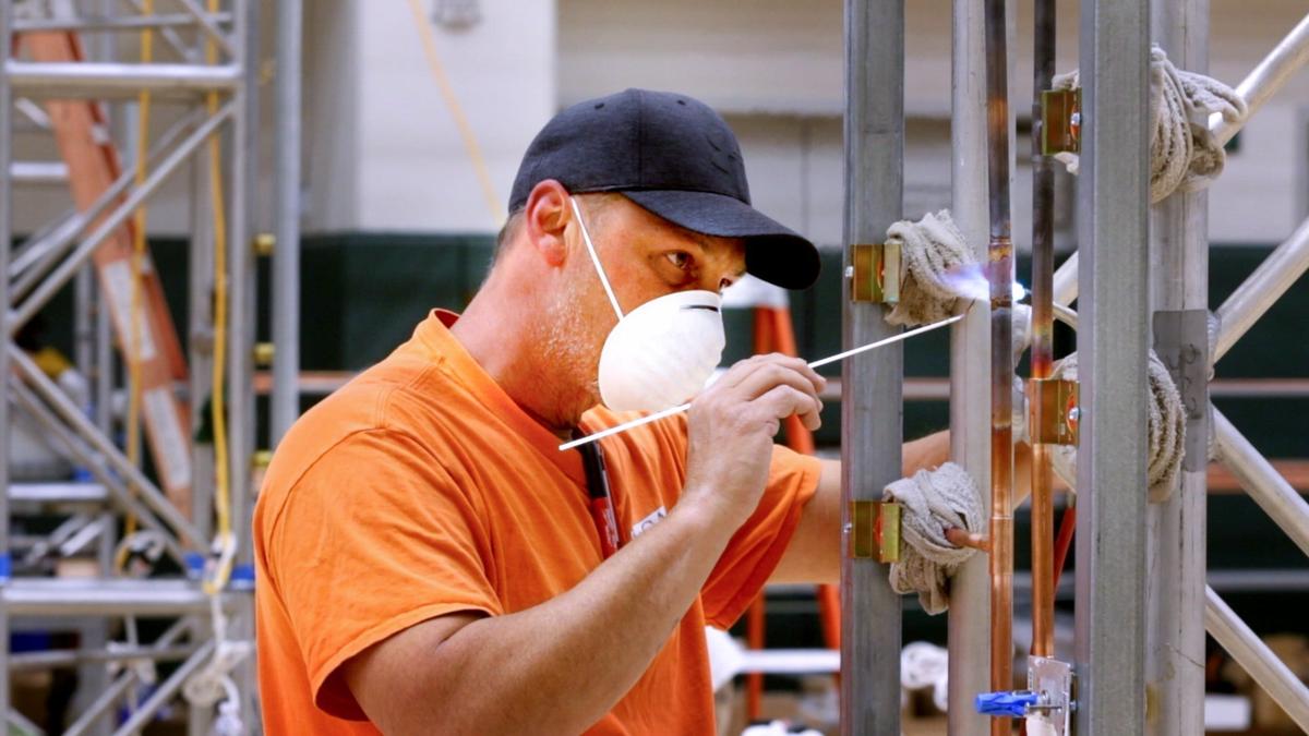 Camdon Castillo with McCall Plumbing and Mechanical solders together copper pipes that will deliver oxygen to COVID-19 patients as workers prep the Cal Poly Rec Center as an alternate care site.