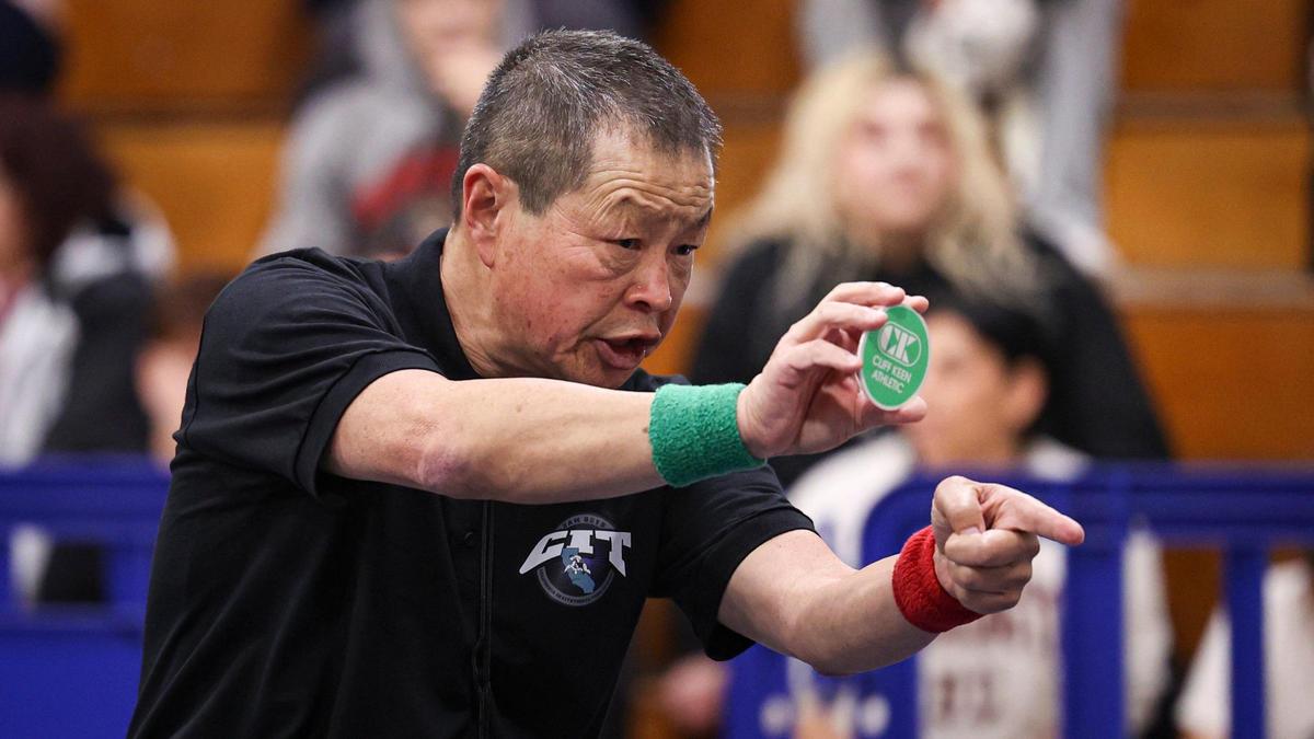 Referee Jim Gin asks the green-designated wrestler to choose a starting position. He was one of the long-serving officials at the California Invitational Tournament at Morro Bay High School on Jan. 19, 2024.
