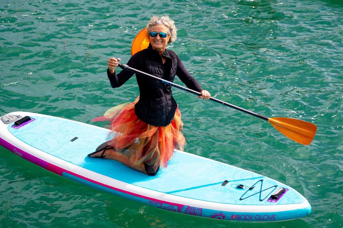 A witch wearing a festive fall skirt paddles along at the Witches and Warlocks Paddle in Morro Bay on Saturday, Oct. 25, 2025. The 13th annual paddle attracted hundreds of witches and creatures of the night taking to the water on paddleboards, kayaks and other small craft.