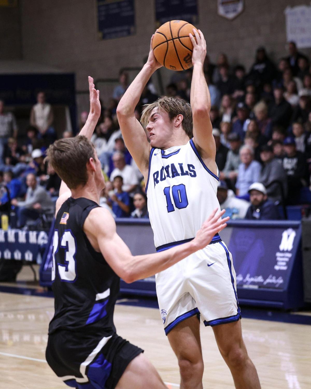 Brayden Mott swings a pass while being defended by Dallin Crawford. Mission Prep beat Frontier 67-55 on Feb. 21, 2025, to advance to the Division 2 CIF Central Section basketball final.