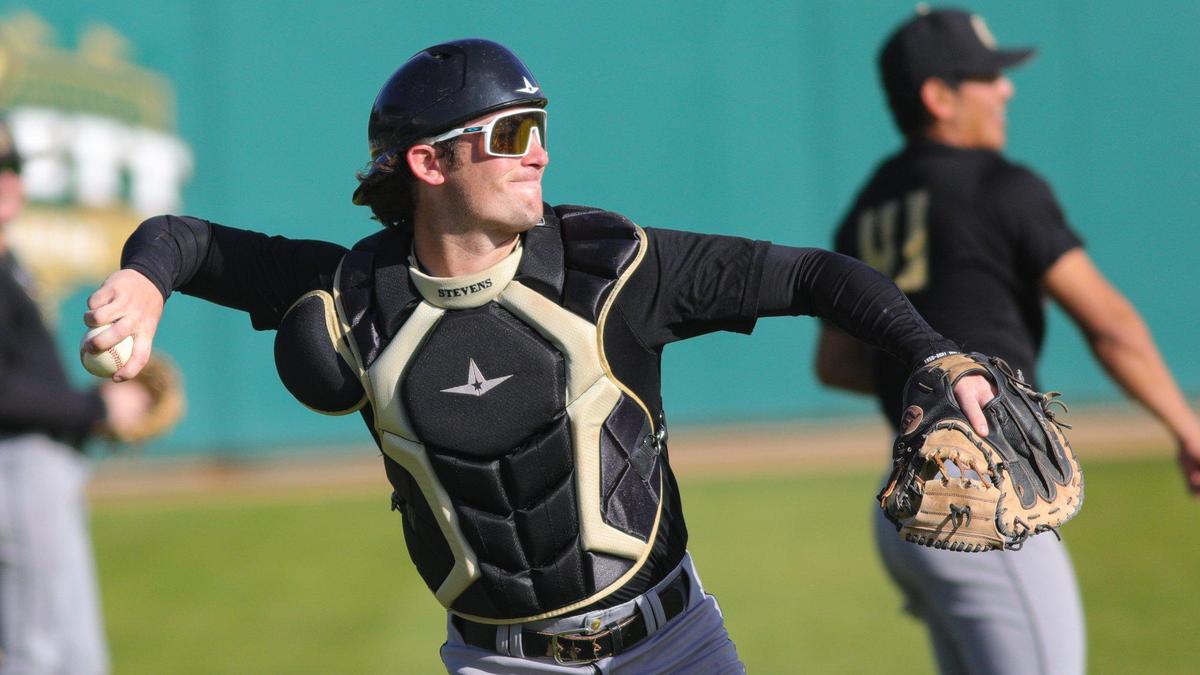 Catcher Carson Stevens warms up as the Cal Poly baseball team practices on Feb. 14, 2023, before opening the baseball season against Missouri State.