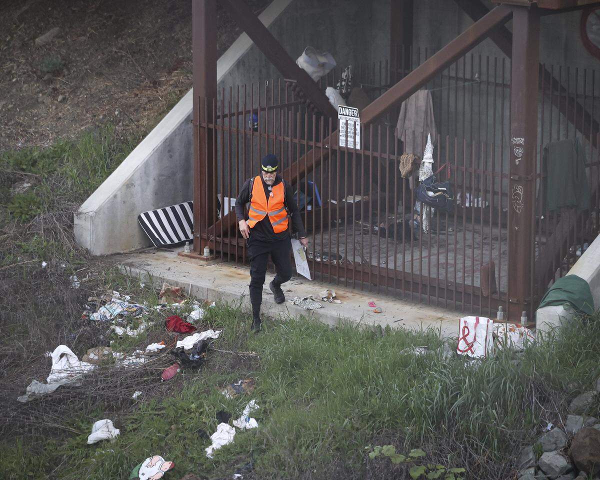John Townsend looks for a person but only found discarded items under a pedestrian bridge over the Union Pacific Railroad tracks. Volunteers making the Point-In-Time Count of unhoused were out before dawn on Jan. 27, 2026.