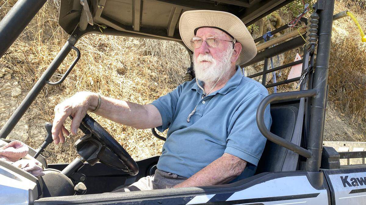 John Claudy keeps an eye on the Gifford Fire burning near his area behind Lopez Lake on Hi Mourntian Road on Aug. 7, 2025. Some homeowners in the area have evacuated, but Ranchita Estates HOA is a shelter-in-place community. Claudy had prepared to leave and was keeping a wary eye on conditions.
