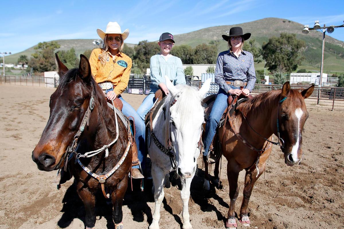 Maddie Owens, center, was diagnosed at age 10 with Ewing osteosarcoma, an aggressive form of bone cancer. Now age 11, she is working with the Cal Poly Rodeo Team through the Make-A-Wish Foundation to fulfill her wish to be a rodeo barrel racer. Helping her out are Cal Poly Rodeo Team assistant coach Sierra Spratt, left, and DeLisa Fracchia.