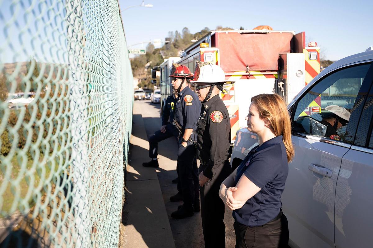 A procession drove from Fresno to Santa Maria on Tuesday, Jan. 11, 2021, carrying the casket of Santa Barbara County firefighter Joey De Anda, who died in a snowboarding accident at China Peak. Atascadero firefighters from Station 2, Engineer Kyle Nakazawa (partially hidden) Fire Capt. Andrew Luera (red hat), Atascadero Fire Chief Casey Bryson (white hat), and Fire Administration Assistance Kelly Arebolo (front) wait for the procession to arrive while watching from a Highway 101 overpass.