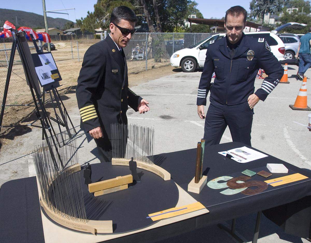 San Luis Obispo fire Chief Garret Olson, left, and former city police Chief Steve Gesell look over a model of the Sept. 11 memorial to be built in front of the fire station on Santa Barbara Street in San Luis Obispo.