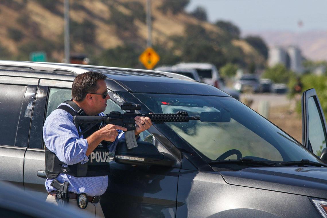A police officer holds a perimeter position on Ramada Drive during the pursuit of shooting suspect Mason James Lira on Thursday south of Paso Robles.