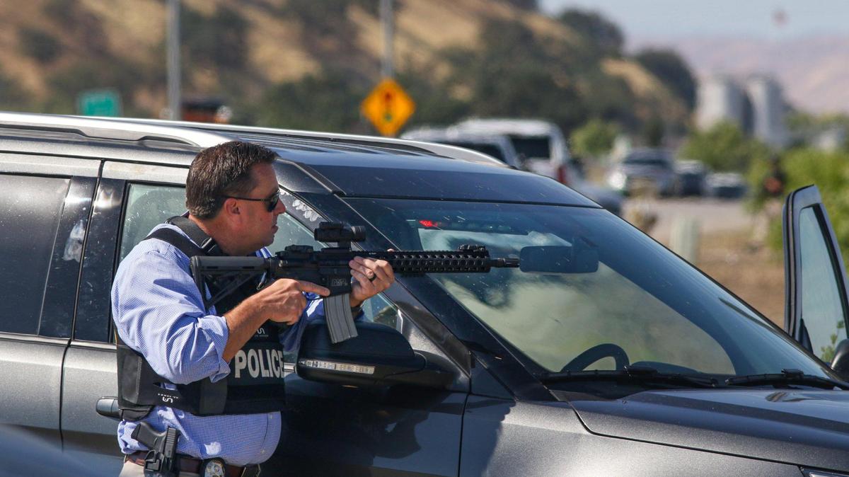 A police officer holds a perimeter position on Ramada Drive during the pursuit of shooting suspect Mason James Lira on Thursday south of Paso Robles.