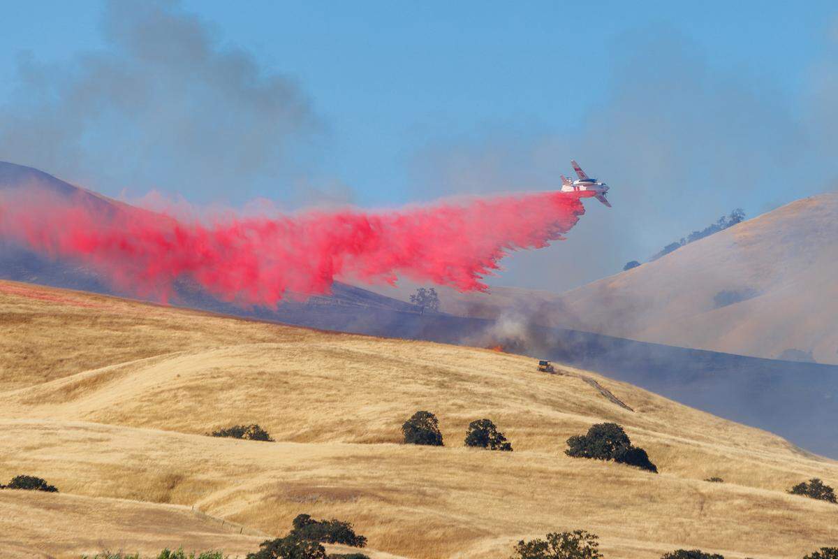 An airplane drops fire retardant on the Vineyard Fire east of San Miguel on Sunday, July 9, 2023.