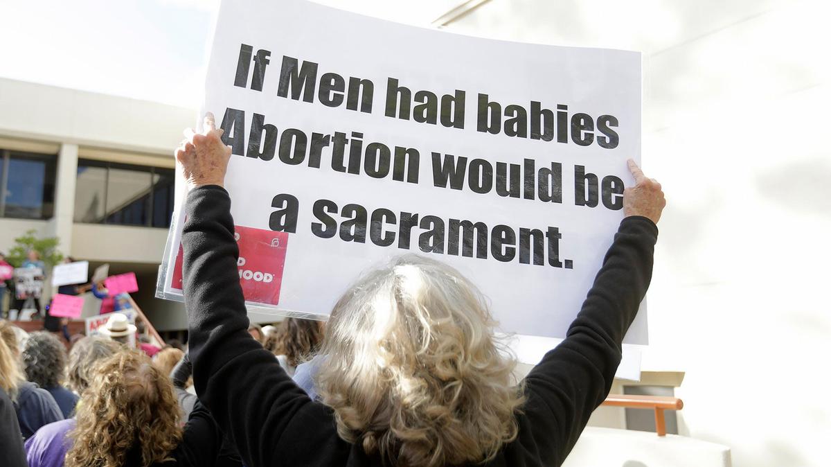 An sign is held aloft at an abortion rights rally.