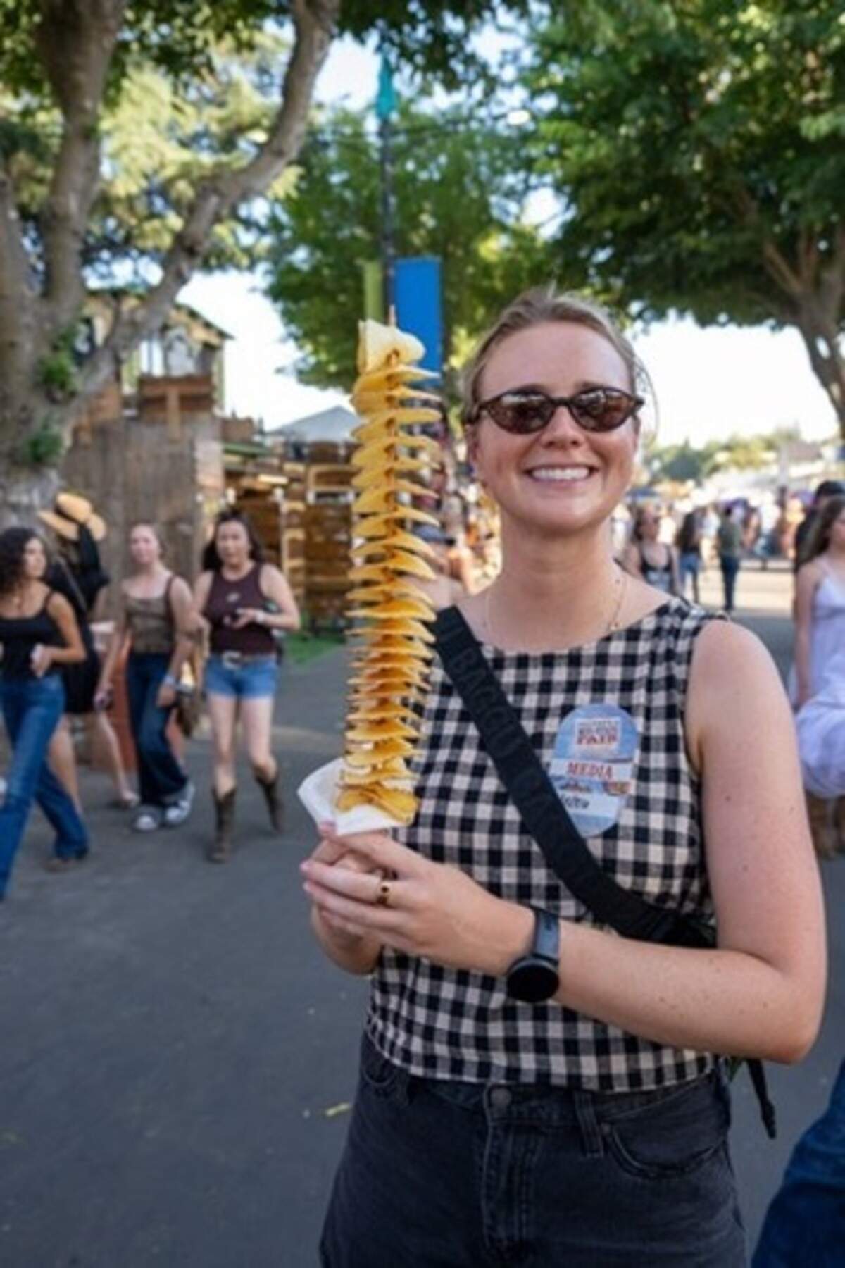 North County reporter Libbey Hanson shows off the size of a potato on a stick at the Mid-State Fair on July 15, 2026.