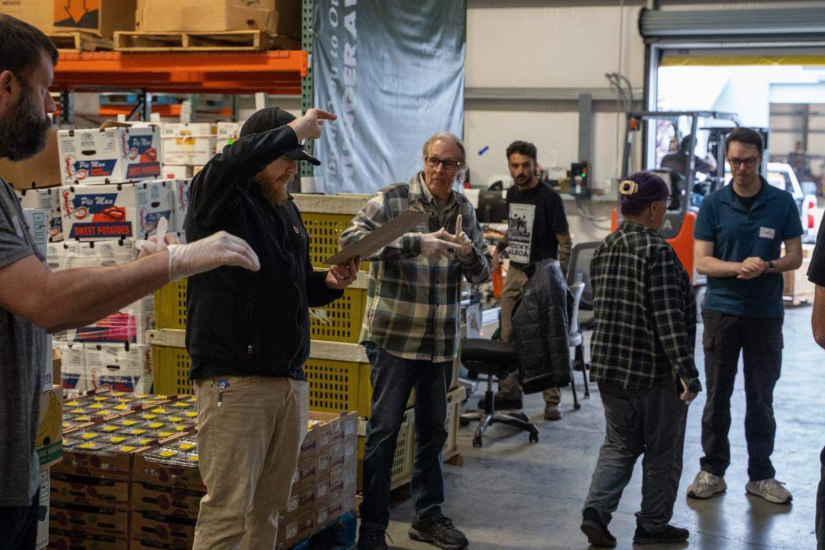 SLO Food Bank volunteers get their marching orders for the day on Friday, Oct. 31, 2025. The SLO Food Bank is projecting a significant increase in demand for its services while the federal shutdown cuts off SNAP benefits.