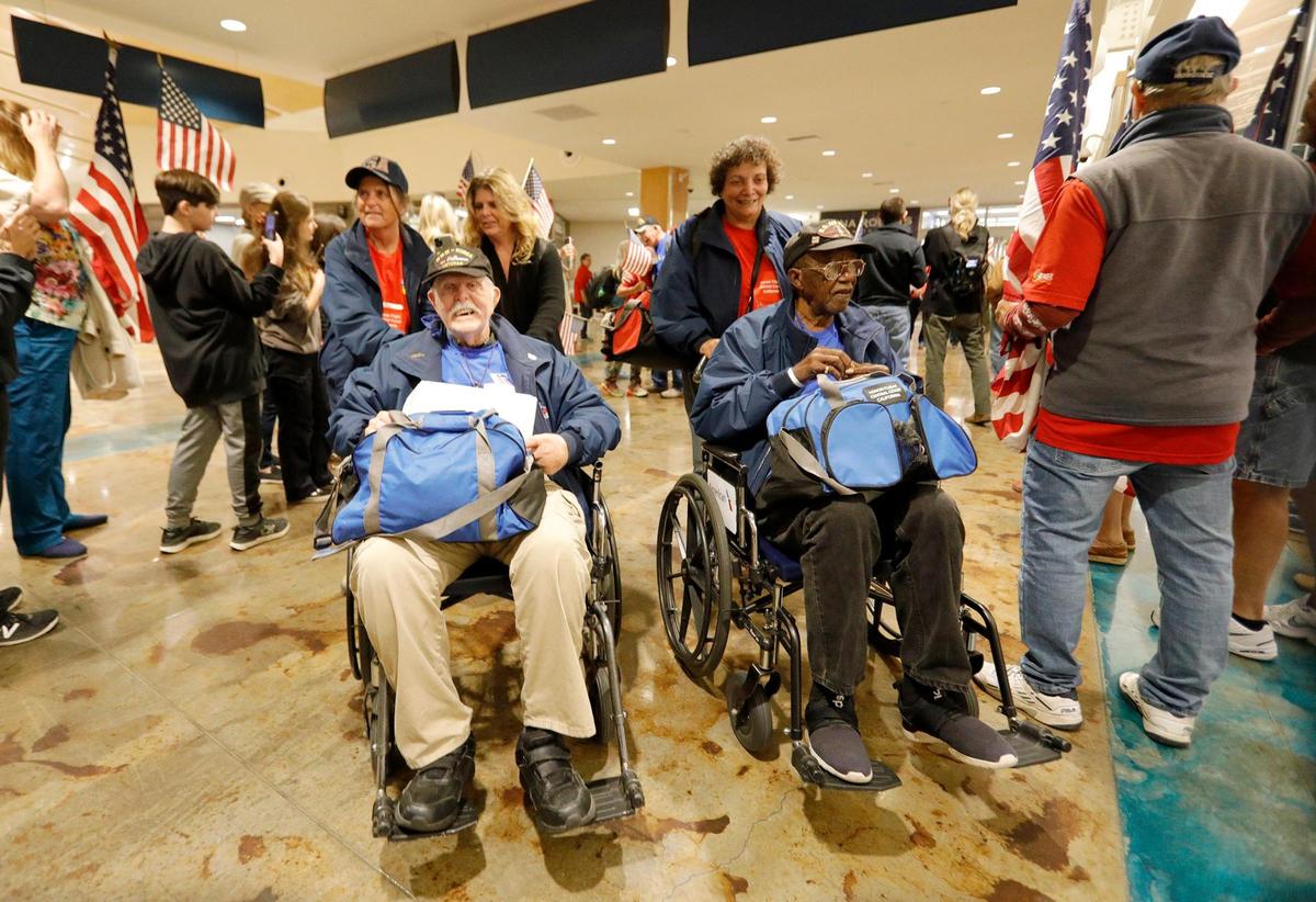 First two veterans exiting the terminal were Brian Moore, left, Navy veteran of WWII and Korean wars. His daughter Monica Wahl was his guardian. Thomas Williams, right, Air Force veteran from the Korean War and his guardian was, Doris Smith. The Central Coast Honor Flight veterans arrived in the San Luis Obispo airport Wednesday night to large, cheering crowd. (Laura Dickinson, The Tribune, San Luis Obispo).