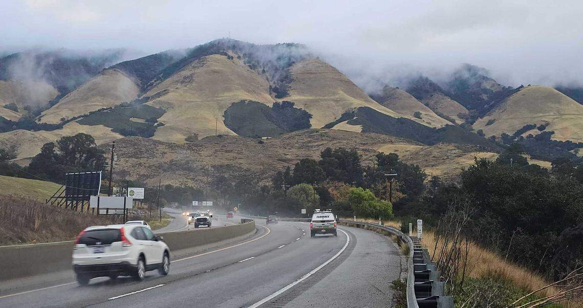 The hills above Cuesta Grade are crested with low clouds as the early morning rain turns to drizzle on Thursday, Dec. 12, 2024.