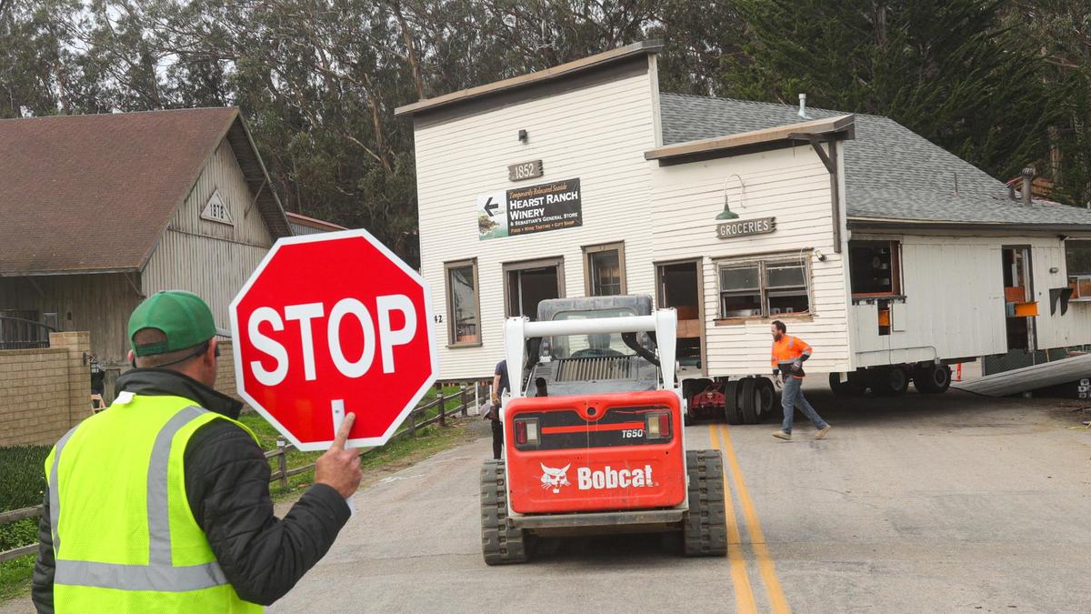 Steven Bishop stops traffic as Sebastian’s General Store is returned to its old location on a new foundation in San Simeon on Jan. 31, 2022.