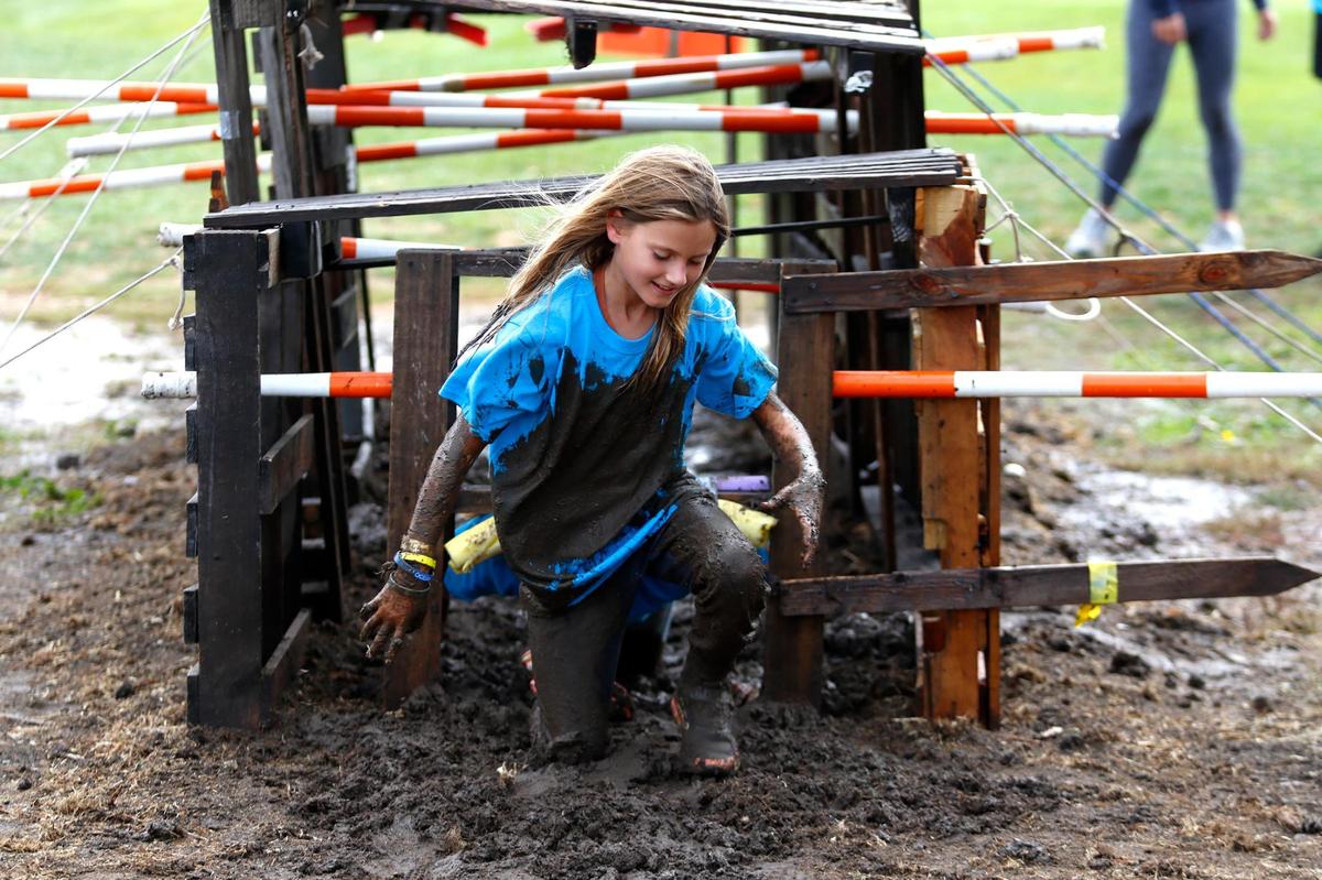 Abigail Durrant, 10, of San Luis Obispo emerges from the “mud tunnel” with her blue shirt turned brown during the sixth annual Laguna Lake September Scramble on Saturday, Sept. 30, 2023.