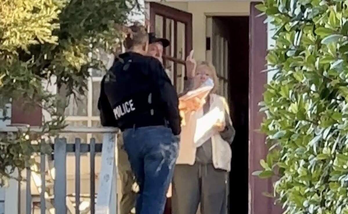 Susan Flores flips off a photographer as investigators serve a search warrant at her home on East Branch Street in Arroyo Grande on Wednesday, May 6, 2026, in the Kristin Smart murder case.