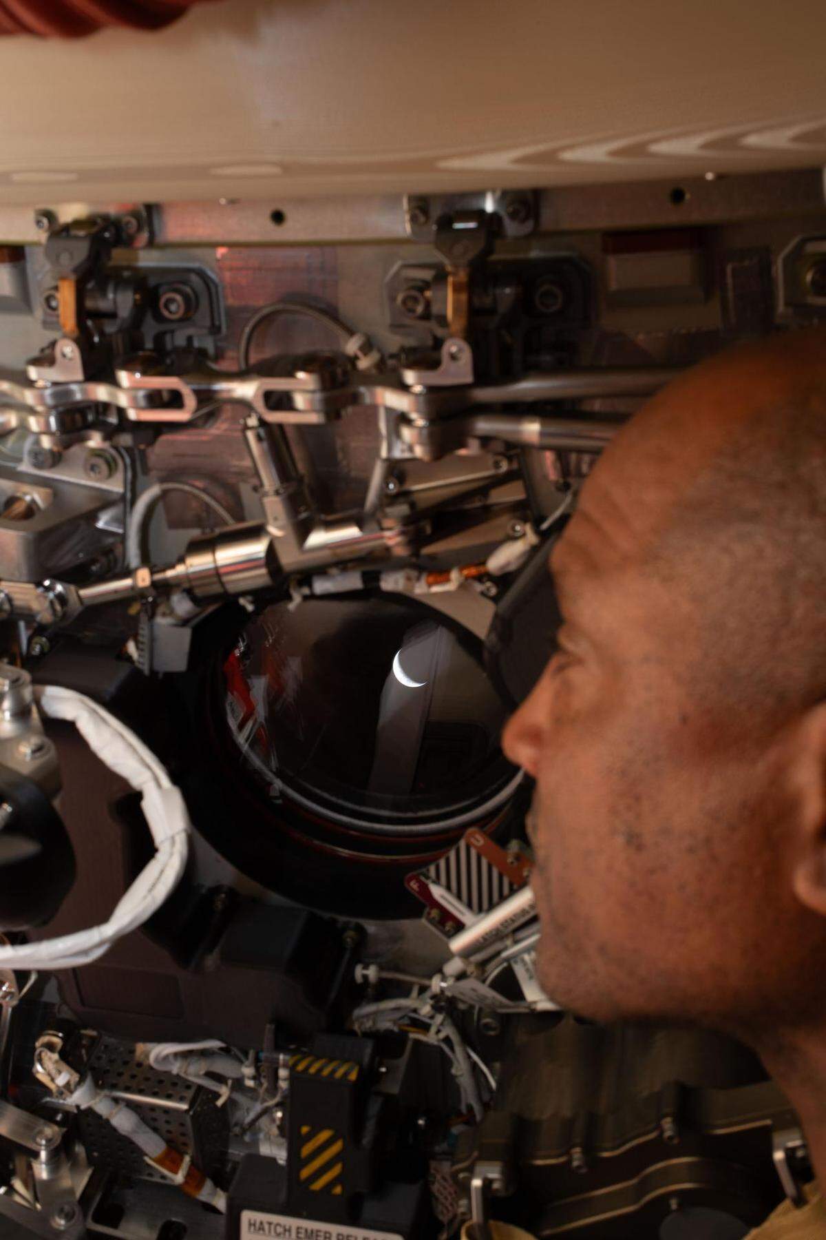 Artemis II pilot and NASA astronaut Victor Glover peers out one of the Orion spacecraft’s windows looking back at Earth ahead of the crew’s lunar flyby on April 6, 2026.
