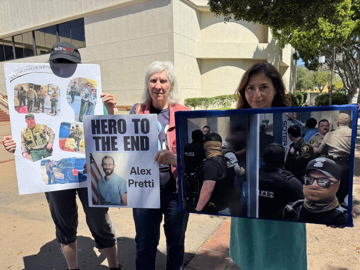 Protesters from Indivisible SLO County hold up anti-ICE sign across the street from the County Government Center on April 7, 2027