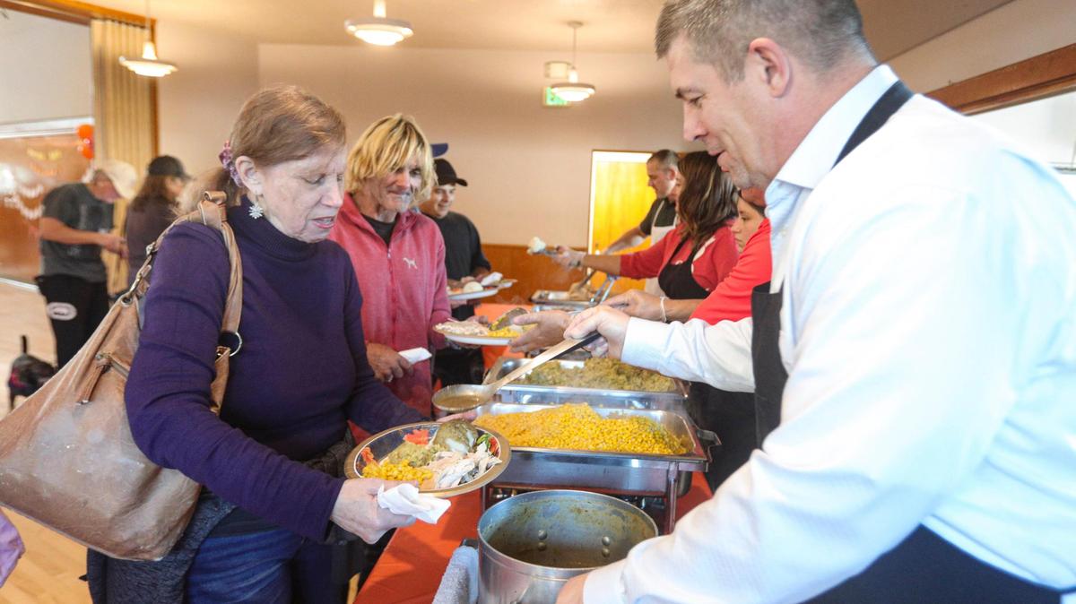 Tamme Jacobson holds her plate as U.S. Army Lt. Col. Ret. David Kramer dishes gravy. The 41st annual Thanksgiving dinner was hosted by the Pismo Beach Police Officers’ Association on Nov. 27 2024. Over 2,500 dinners were prepared and 60 turkeys were cooked for the meal.
