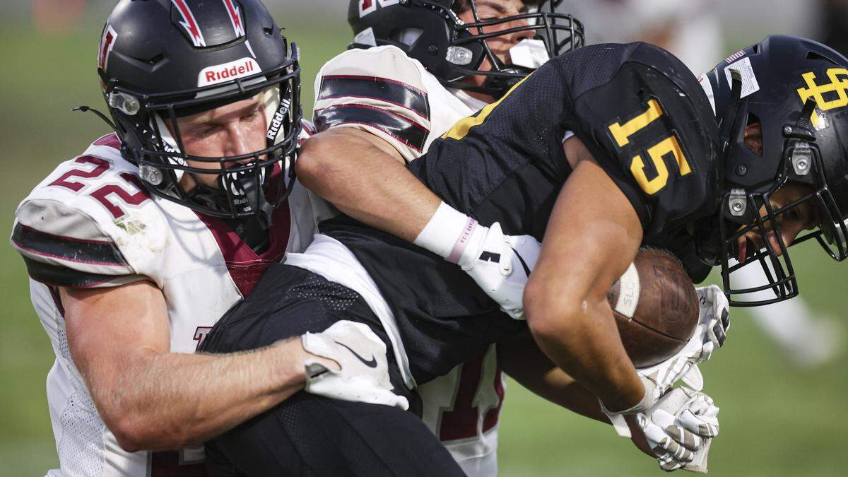 Clinton Martinez is tackled by Evan Doll and Logan Hobbs. San Luis Obispo beat Nipomo 22-16 on Sept. 12, 2025.