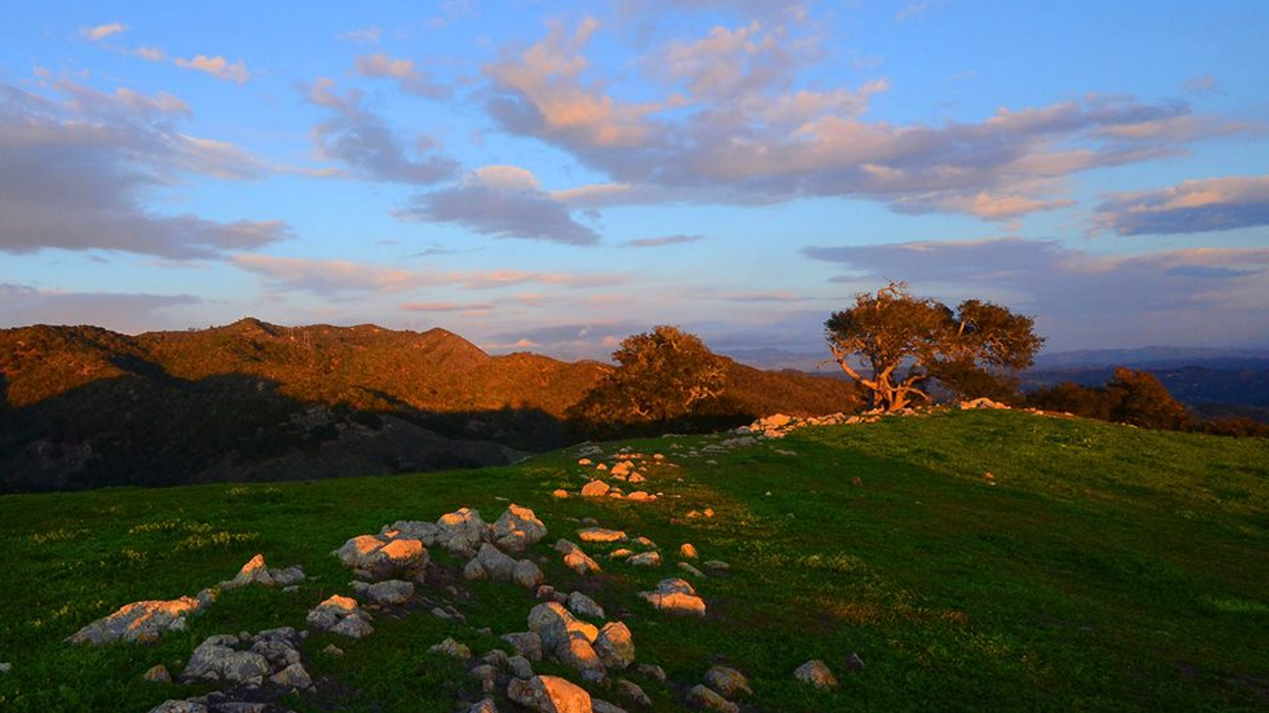 Why do SLO County rainfall totals differ so much between coast and inland areas?