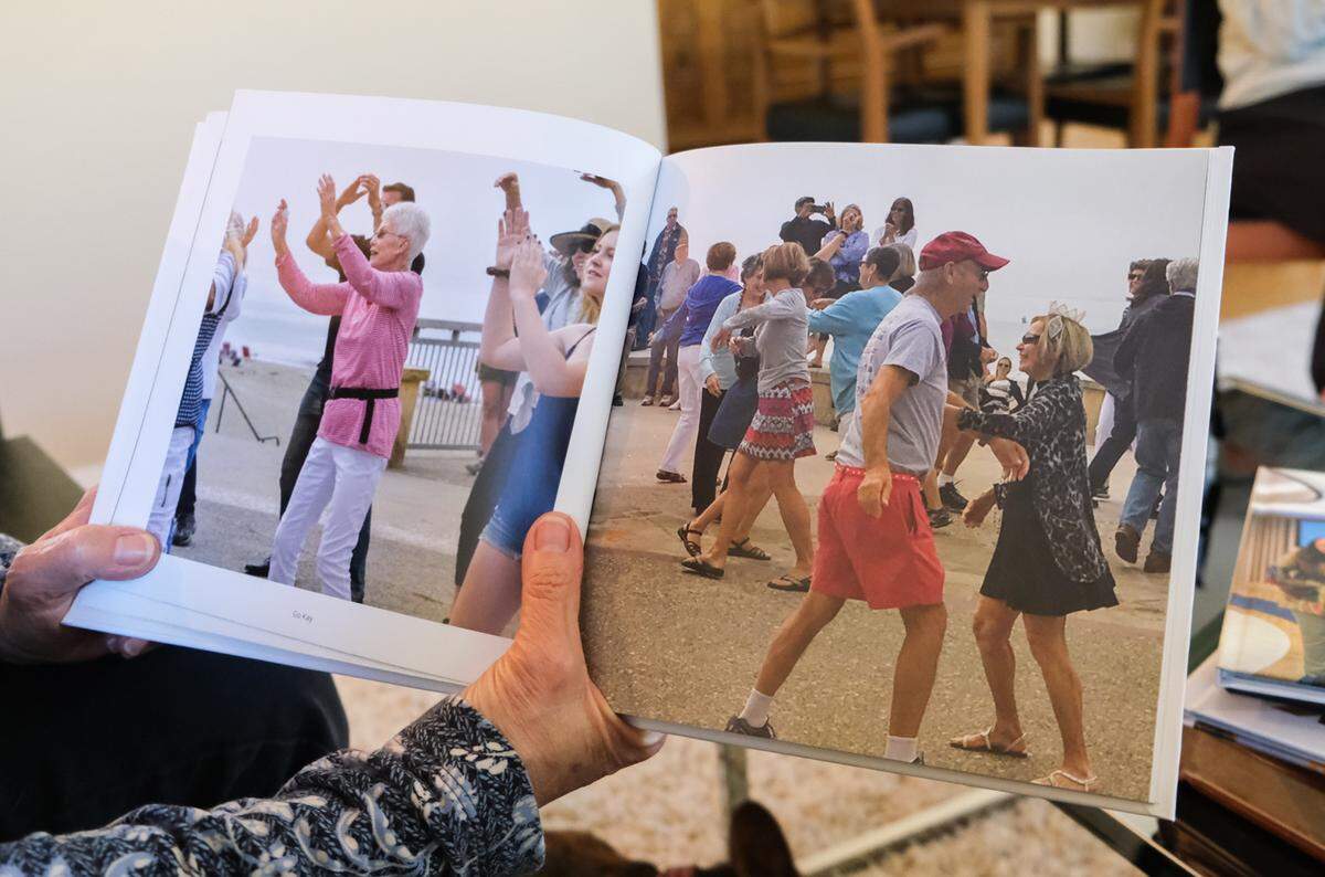 Robin Einkelstein shows a photo album from the 80th birthday of her mother, Carol Goldberg, on Jan 8, 2024. Saul Goldberg planned a flash mob for his wife in Avila Beach that day. Saul died after being hit by a car while cycling in San Luis Obispo on July 23, 2024.
