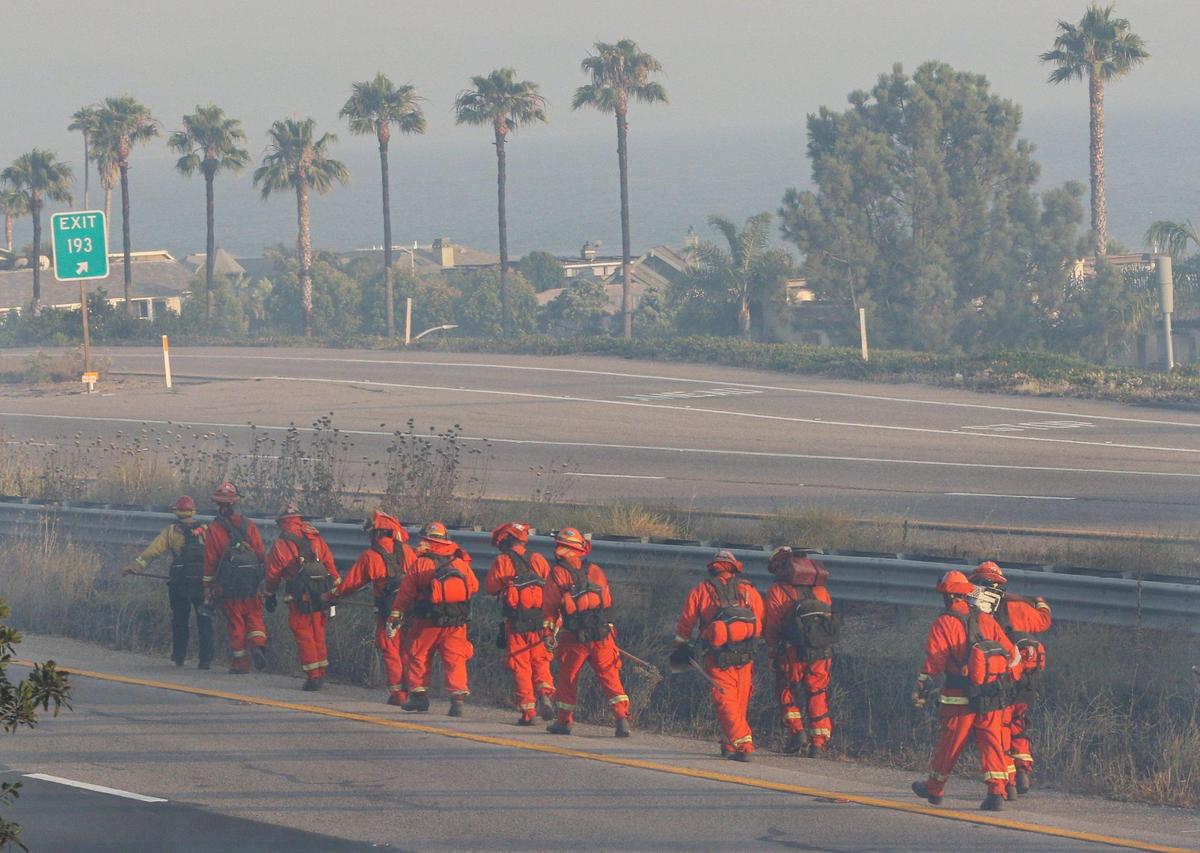An inmate crew works on hotspots along Highway 101. A wind-driven brush fire quickly moved south along Highway 101 along the Shell Beach straits and into Pismo Beach.